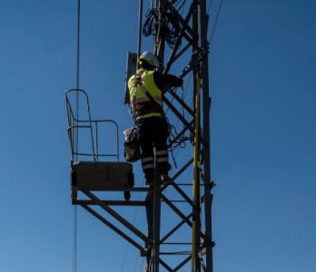 Technicians at work on electricity distribution grid pylon