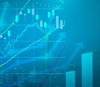 Abstract concept of corporate and financial sustainability: digital graphs with shaded blue arrows, candlestick histograms and green growth lines, against the background of a modern city skyline with skyscrapers and lights.