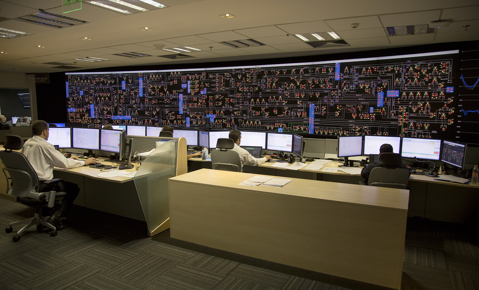 Interno de la sala de control con empleados sentados frente a la pc